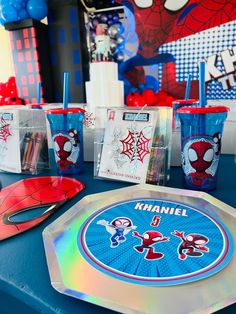 the table is set up with spider - man cups and coasters