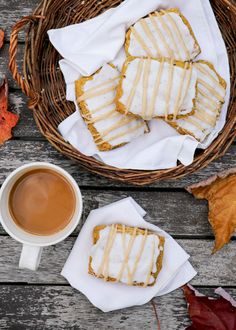 some cookies are sitting next to a cup of coffee on a table with autumn leaves