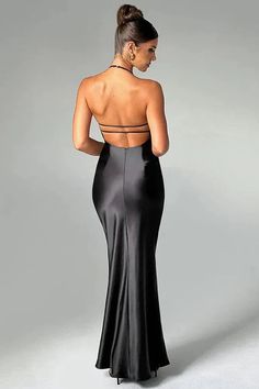 the back of a woman wearing a black evening gown with cut out at the neckline