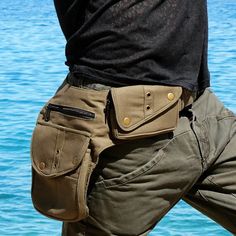 there is a man with his back to the camera wearing cargo pants by the water