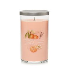 yankee candle with oranges and leaves on the front, in a glass container against a white background