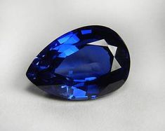 a large blue diamond on a white surface with the top half cut open to show it's shape