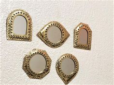 four mirrors are arranged on a white wall