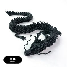 a black dragon figurine sitting on top of a white surface