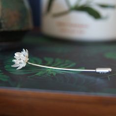 Lotus Flower Brooch Pin Flower - 16mm diameter Stick Pin is sterling silver 1.2mm wire approx 6cm long. Fastened with a simple, silver push-on stopper. With a bright matt-white silver finish & polished highlights. This pin can be worn on a lapel, tie, scarf or hat. Bear in mind the pin may leave a small hole on the garment. Handmade by me, in Wales, UK. Packaged in a gift-box and ready to give as a present. Matching pieces available : https://www.etsy.com/uk/listing/616340051 Did you know? -The Lotus Flower Jewelry, Lotus Necklace, Lotus Earrings, Wales Uk, Tie Scarf, Rose Jewelry, Jewellery Handmade, Yoga Jewelry, Flower Accessories