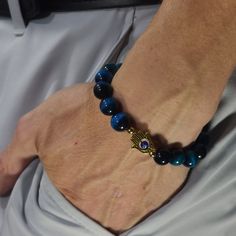 "PLEASE READ FULLY *SIZING INSTRUCTIONS BELOW* This bracelet is made of all pure 10mm Blue Tiger's Eye with 24k gold-filled beads and a gold colored silver-plated Fatima's hand with a colored, glass Evil Eye that spins.  You can select from a variety of colors for the eye!   Tiger's Eye is used to promote confidence and mental strength. It is also especially good at shielding from evil energies. The Evil Eye protects you from Evil Eye.  Made with care by me. *Sizing: 1st, measure your wrist with string.  Bracelets fit best at least 1/4\" larger than the wrist. IMPORTANT: Bracelets fit smaller than the length specified.  For 10mm bracelets, add 1cm (7/16in). For 8mm bracelets, add 8mm (3/8in) to the size. For 6mm bracelets, add 6mm (3/16in) to the size.  Please feel free to ask me about Siz Evil Eye Bracelet With Gemstone Beads As Gift, Evil Eye Bracelet With Round Gemstone Beads, Gift Evil Eye Bracelet With Gemstone Beads, Spiritual Yellow Gold Round Beads Bracelets, Spiritual Yellow Gold Bracelets With Round Beads, Spiritual Evil Eye Bracelet With 8mm Beads, Spiritual Yellow Gold Beaded Bracelets, Gold Evil Eye Bracelet With 8mm Beads For Gifts, Gold Evil Eye Bracelet With 8mm Beads As Gift