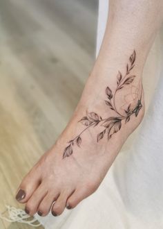 a woman's foot with a flower tattoo on it