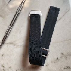 Available In 20mm Elastic watch straps made from classic parachute band material, in Black, and brushed steel hardware. Each watch band employs a hook and loop-style system. The sliding steel "loop" adjusts easily with limited resistance while providing a snug, tight, or loose fit on demand. #WhereAsYouLike Seriously, these parachute watch straps are one of the most comfortable in existence. No, not ours specifically, but this style of strap. It is an ideal all-season watch strap with Summer in Black Watch Bands With Wrist Strap For Everyday Use, Black Watch Band For Everyday Use, Adjustable Wear-resistant Watch Bands, Adjustable Wear-resistant Functional Watch Bands, Wear-resistant Adjustable Watch Bands, Durable Modern Watch Bands For Everyday Use, Everyday Watch Band With Stainless Steel Clasp, Adjustable Black Watch Bands For Everyday, Watch Companies