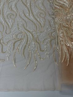 two pieces of white fabric with gold thread and sequins