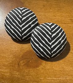 two black and white buttons sitting on top of a wooden table