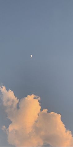 the moon is shining in the sky above some clouds