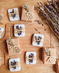 soaps wrapped in brown paper and tied with twine on a wooden table next to dried flowers