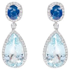 18 Karat White Gold Aquamarine, Blue Sapphire and Diamond Cocktail Drop Earrings This impressive aqua sky aquamarine, azure blue, and diamond long hanging earring is glorious. The solitaire perfect pear shape aquamarine is surrounded by a single row of a round diamond cluster in solid white gold, making it more elegant. The top part of the earring consists of a cushion cut solitaire blue sapphire held in grain prongs and surrounded with a single row of pave set diamond round cluster adjoining th Luxury Blue Drop Earrings, Luxury Aquamarine Blue Earrings, Luxury Blue Aquamarine Earrings, Blue Aquamarine Fine Jewelry Earrings, Fine Jewelry Blue Aquamarine Earrings, Blue Aquamarine Earrings Fine Jewelry, Elegant Blue Aquamarine Earrings, Blue Diamond Earrings, White Gold Drop Earrings