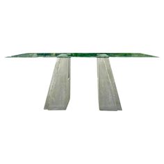 a glass table with two metal legs on the top and one leg in the middle