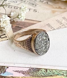 This fantastic Victorian ring features a glittering, oval-shaped natural pyrite stone set in 10k gold. The stone is an oval shape with naturally occurring fractures and crystals. The stone is set with a closed back and is very secure. The shoulders of the ring have wonderful etched details. This great ring is both gorgeous and unusual, a real conversation starter!  This is a great antique ring with lots of character, ready to wear, gift, or collect.  DETAILS Size: fits right around a US 6 - 6.25 Vintage Rings With Natural Inclusions For Gift, Gold Oval Signet Ring In Art Deco Style, Oval Art Deco Signet Ring As Gift, Vintage Jewelry With Natural Inclusions For Weddings, Anniversary Jewelry With Natural Inclusions In Oval Shape, Vintage Gemstone Jewelry For Memorial, Vintage Wedding Jewelry With Natural Inclusions, Vintage Gold Ring For Memorial, Oval Art Deco Signet Ring For Gift