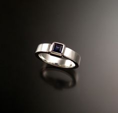 "This is a sturdy ring that contains a 4mm square natural deep blue/purple Iolite. The stone is bezel set on a 2mm thick by 4mm wide sterling silver band. It is sturdy and comfortable to wear. I can make this ring for you in any size between 4 and 9. Iolite is a very true blue natural stone found in Bolivia. It rates a 7 on the Mohs scale for hardness. The stones are very clean top blue color and well cut. Be aware that in ring sizes smaller than 7 the stone will look slightly larger in scale wi Modern Sterling Silver Emerald Cut Sapphire Ring, Modern Sapphire Ring With Rectangular Shape, Emerald-cut Sapphire Ring With Bezel Setting, Modern Rectangular Sapphire Ring For Anniversary, Modern Emerald Cut Sapphire Ring With Polished Finish, Modern Emerald-cut Sapphire Ring With Polished Finish, Modern Rectangular Sapphire Anniversary Ring, Modern Jewelry With Bezel Setting And Square Cut, Modern Sterling Silver Sapphire Ring With Tension Setting