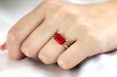 A slim rectangular stone set horizontally in high-polish prongs is what this unique Ruby ring beautifully flaunts. This July birthstone brings a vivid charm that you can wear or wrap as a gift for a special occasion. This lovely piece can be styled with other handmade rings or worn on its own. Exquisite jewelry piece. Breathtaking gemstone piece. Charming choice for a promise or engagement ring. Classy and chic jewelry ring. Ring size is customizable. Product specifications Jewelry Information M Modern Ring With Rectangular Accent Stones, Modern Rings With Rectangular Accent Stones, Square Cut Polished Jewelry As Gift, Polished Square Cut Jewelry For Gifts, Modern Rectangular Rings With Accent Stones, Rectangular 14k Gold Jewelry With Accent Stones, Formal Ruby Ring With Rectangular Stone, Minimalist Solitaire Rectangular Jewelry, Modern Radiant Cut Gemstone Ring