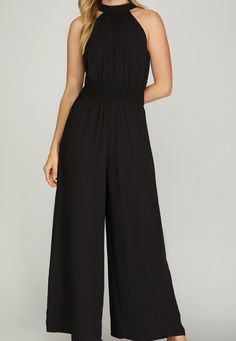 Take a daring leap into style with the Natalie Jumpsuit in sleek black. Featuring a wide leg for a bold look, a waist-smocked design for a flattering fit, and a halter neckline with a back tie for added detail. Made with 100% polyester, this jumpsuit is perfect for taking risks and making a statement. Taking Risks, Halter Jumpsuit, Live Fit, Bad Habit, Jumpsuit Black, Stunning Outfits, Long Blonde Hair, Leg Design, Halter Neckline