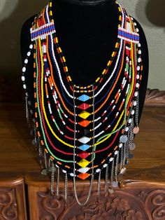 "Lovely colorful African handmade draping jewelry necklace. This is a bright and colorful ceremonial necklace, handmade on the Masai Mara in Kenya, Africa. It is a rainbow of bright colors, plus lots of dangling jingling silver charms which drape across the chest. Over 12 beautiful decorative strands of beads. There is just something about Africa that seeps into your soul and stays with you. I set out to paint Utah and all of its beauty...but my heart keeps returning to Africa again and again. I Traditional Beaded Long Bridal Necklace, Handmade Multicolor Bridal Necklace With Round Beads, Vibrant Handmade Dangle Jewelry, Large Beads For Celebrations And Festivals, White Artisan Jewelry For Festivals, Multicolor Round Beads Bridal Necklace As Gift, Artisan White Jewelry For Festivals, Traditional Bridal Necklace With Beaded Chain, Multicolor Bridal Necklace With Round Beads