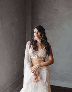 Verona is a stunning ivory with lehenga with touches of gold and pink, adorned with sequins, stones, pearls, and tassels all over. The blouse is delicately crafted with three-dimensional flowers and straps with pearls. DELIVERY TIMEPlease allow 12-16 weeks for your outfit to arrive. FABRIC DETAILSNet Professional cleaning only. Glamorous Designer Sharara With Pearl Embroidery, Glamorous Festive Lehenga With Pearl Embroidery, Glamorous Festive Sharara With Pearl Embroidery, Glamorous Choli With Pearl Embroidery, Cream Hand Embellished Lehenga For Reception, Gold Wedding Choli With Pearl Embroidery, Gold Choli With Pearl Embroidery For Wedding, Hand Embellished Cream Lehenga For Reception, Glamorous Choli With Pearl Embroidery For Receptions