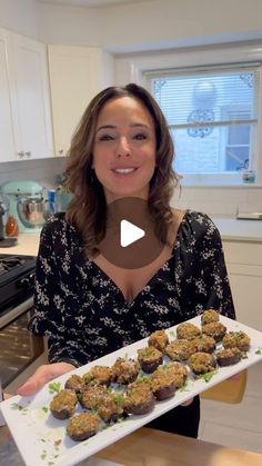 a woman is holding a tray of food in her hands and smiling at the camera