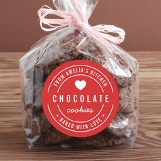 chocolate cookies wrapped in cellophane and tied with pink ribbon on wooden table top