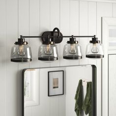 a bathroom vanity with three lights and a mirror