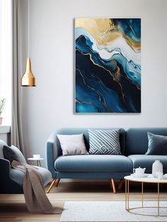 a living room with blue couches and paintings on the wall above them, along with a coffee table