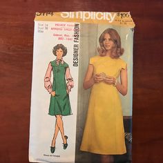 a woman in a yellow dress standing next to a sewing pattern