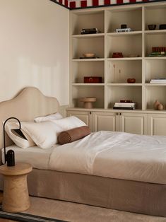 a bed sitting in a bedroom next to a book shelf