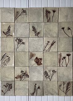 a tile wall with pressed flowers on it