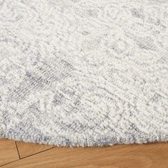 a white and gray rug on top of a wooden floor