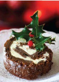 a small pastry decorated with holly leaves on a red and white checkered table cloth