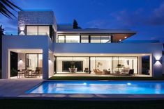 a modern house with a swimming pool at night