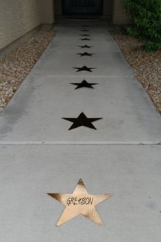 the sidewalk is lined with three star decorations