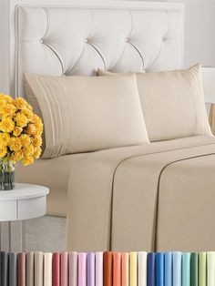 the sheets and pillow cases are lined up with yellow flowers in a vase next to them