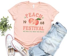 Retro Peach Tshirt, Summer Peachy Graphic Tshirt, Just Peach Shirt, Fruit Tshirt, Festival Tee, Retro Peach Festival Tshirt, Groovy Tee Keen BE SURE TO CHECK SIZING CHART SO YOU CAN CHOOSE THE RIGHT SIZE FOR YOUR PREFERRED FIT.  Our solid color unisex tees are super soft ring-spun cotton with just the right amount of stretch. Because they are unisex, they may be a bit loose on some ladies, or more fitted for some men, depending on body type and preference of fit. We use premium name brands like Bella+Canvas and Rabbit Skins. (Tie dye shirts and Sweat Shirts are Gildan brand) Care Instructions: Turn inside out and machine wash on cold gentle cycle. Use a mild detergent and wash with like colors. Do not use fabric softeners or dry clean. Tumbler dry on low or, even better, hang to dry. If ne Peach Short Sleeve T-shirt For Summer, Trendy Peach T-shirt With Letter Print, Trendy Peach Short Sleeve T-shirt, Peach Short Sleeve Shirt For Summer, Trendy Peach Relaxed Fit T-shirt, Trendy Relaxed Fit Peach T-shirt, Summer Peach T-shirt With Graphic Print, Summer Peach Cotton Shirt, Casual Peach Summer Shirt