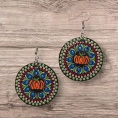 The Autumn inspired dot mandala design was carefully hand painted on 1.5 inch round wooden circles. With a fall pumpkin in the center, the intricate mandala is embellished with glitter and finished with a glossy top coat for added shine and durability. Total drop length is 2.25 inches. Dot Painted Earrings, Dot Mandala Earrings, Intricate Mandala, Mandala Earrings, Dot Earrings, Autumn Inspired, Painted Earrings, Dot Mandala, Etsy Earrings Dangle