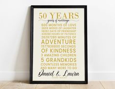 a framed poster with the words 50 years on it in gold and black, against a white wall