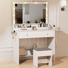 a white vanity with lights on it and a stool in front of the mirror that is open