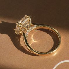 a diamond ring sitting on top of a tan cloth covered table next to a pair of scissors