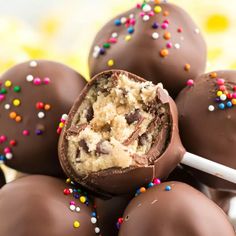 chocolate covered candy balls with sprinkles and a white stick in the middle