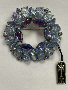 Vintage 1950-1960 New with original tag TRIFARI Etoile Blue Rhinestone Wreath Brooch, Blue Lava Nugget Stones and Blue Aurora Borealis Rhinestones! Designed by Alfred Philippe famous designer who worked for Cartier. This incredible brooch is crown Trifari signed and features oval shaped blue AB sheen lava stones, perfect little nuggets! There are also teensy blue aurora borealis chatons and vivid blue aurora borealis marquise rhinestones, all paste set in rhodium. This is such a fantastic piece, Rhinestone Wreath, Blue Lava, Circle Wreath, Blue Aurora, Vintage Jewelry Antique, Blue Aurora Borealis, Vintage Rhinestone Brooch, Jewelry Board, Trifari Jewelry