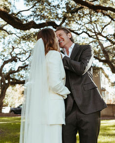 a bride and groom standing in front of a large oak tree at the end of their wedding day