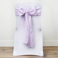 the back of a white chair with a purple bow on it's sashel