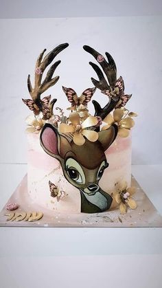 a cake decorated to look like a deer with butterflies on its antlers and head