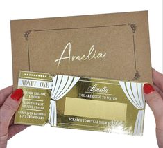 a person holding up a card with the name amelie on it and an envelope in front