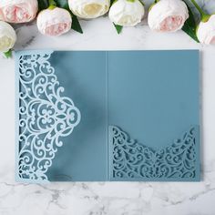 a blue wedding card with an intricate laser cut design on the front and back side