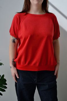 Sixties/Seventies Red Sweatshirt Tee. Raglan Sleeve. Ribbed Collar, Cuff & Hem. No Content Label No Size Tag Excellent Vintage Condition - Small Hole in Back. All Measurements Taken Flat Chest-23.5" Shoulder to Hem-23.5" All Sales Are Final. We have taken the time to note all size measurements and the condition of each piece so please look over all the information of the garment you are considering purchasing. Please note that all items are sold in "Vintage Condition". If you have any further qu Red Retro Relaxed Fit Tops, Retro Crew Neck Solid Tops, Red Sweatshirt, Sweatshirt Short Sleeve, Vintage Shorts, Flat Chest, Raglan Sleeve, Sweat Shirt, Gender Neutral