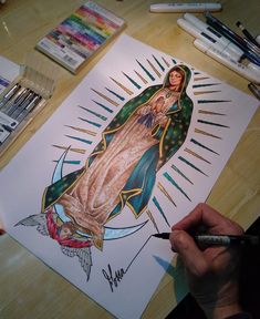 a drawing of the virgin mary is shown on a table with markers and crayons